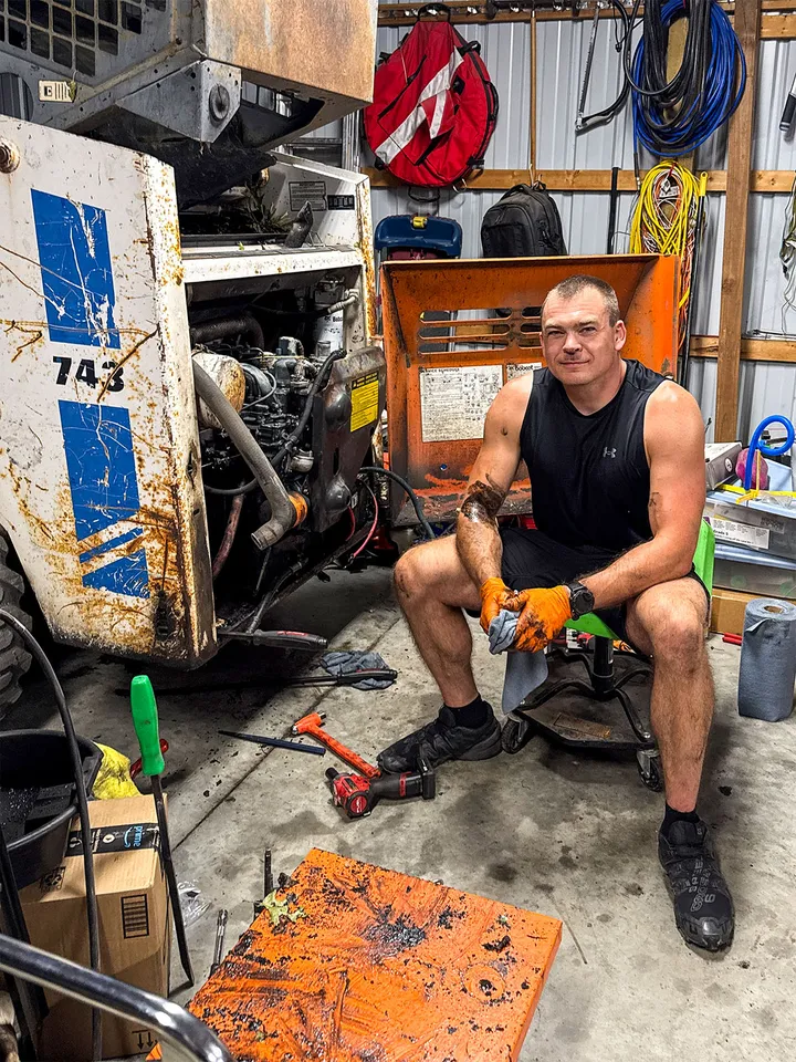 Chris Westlund in his shop, pulling the engine out of a Bobcat 743 skid steer