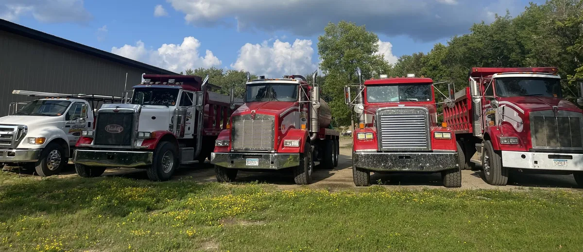 Shepard Excavating's dump trucks lined up outside the shop